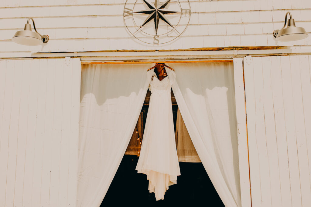 Bride's dress hanging from barn doors at The Hinterland CT