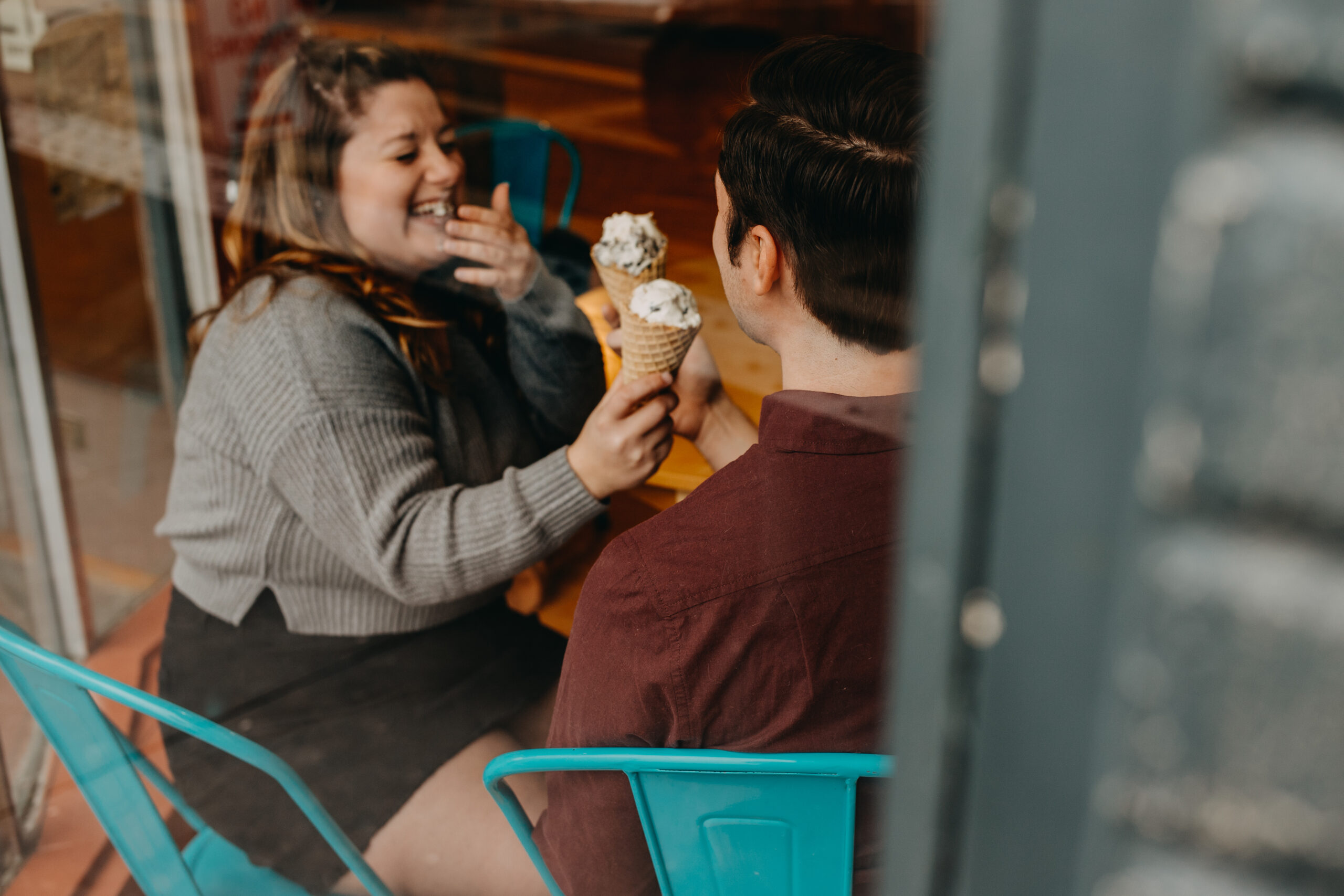 Couple laughing together during a date eating ice cream