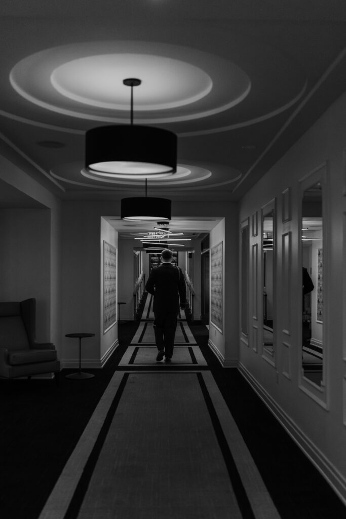 Groom walks down The Goodwin Hotel Hartford CT hallways 