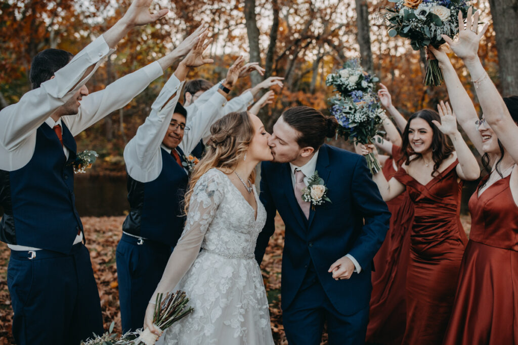 Bride and groom kissing in front of the wedding party Connecticut Fall wedding photography 